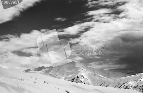 Image of Black and white ski slope and sky with clouds in evening