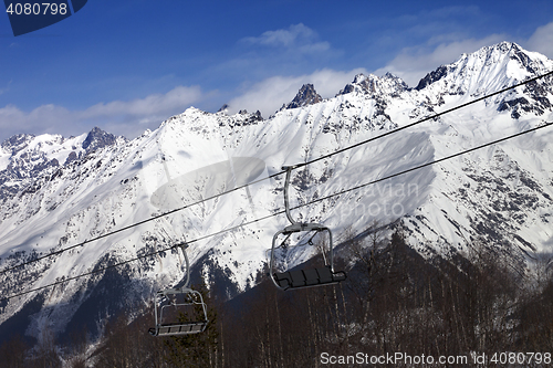 Image of Ski resort with chair lift and snow mountains at nice sunny day