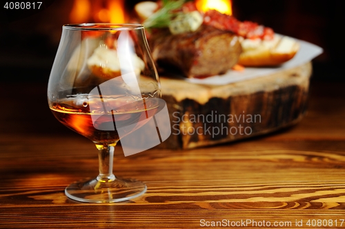 Image of glass of cognac on the background  a meat dish