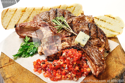 Image of fried steak on a wooden board