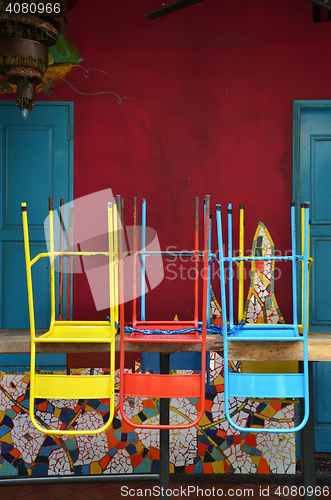 Image of Colorful chairs on a wooden table