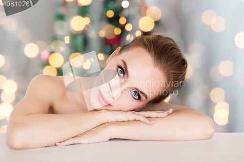 Image of beautiful woman face over christmas lights