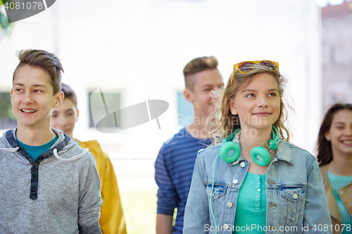 Image of group of happy teenage students walking outdoors