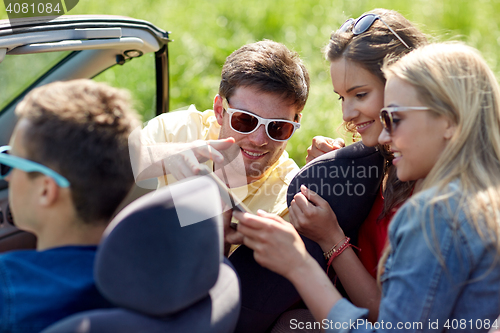 Image of friends with tablet pc driving in cabriolet car