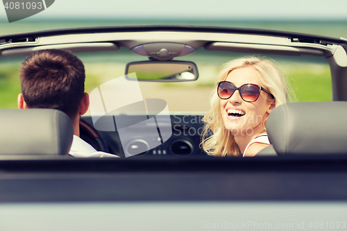 Image of happy man and woman driving in cabriolet car