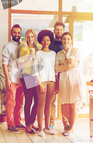 Image of happy smiling creative team with coffee in office