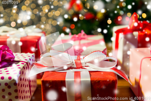 Image of close up of gift boxes over christmas tree lights