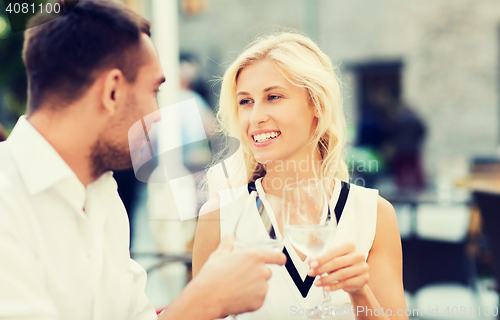 Image of smiling couple drinking champagne at cafe