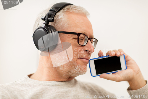 Image of happy senior man with smartphone and headphones