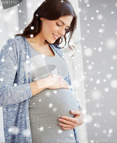 Image of happy pregnant woman with big tummy at home