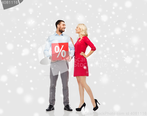 Image of happy couple with red sale sign over snow