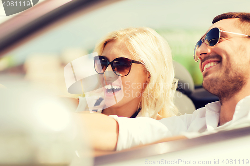 Image of happy man and woman driving in cabriolet car