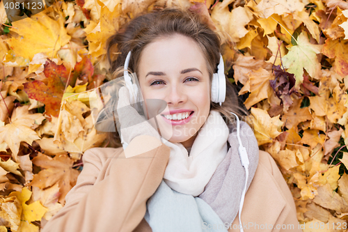 Image of woman with headphones listening to music in autumn