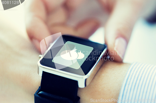 Image of close up of hands with message icon on smartwatch