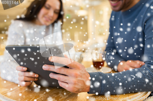 Image of happy couple with tablet pc drinking tea at cafe