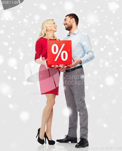 Image of happy couple with red sale sign over snow