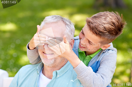 Image of grandfather and grandson playing at summer park