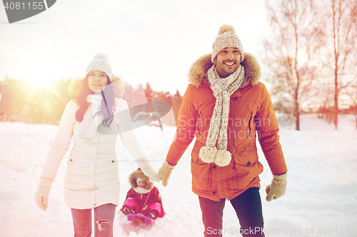 Image of happy family with sled walking in winter outdoors