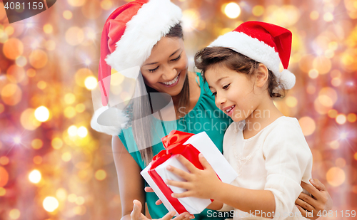 Image of happy mother and child girl with gift box