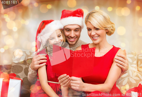 Image of smiling family reading postcard
