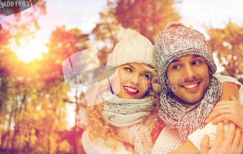 Image of happy couple in warm clothes over autumn