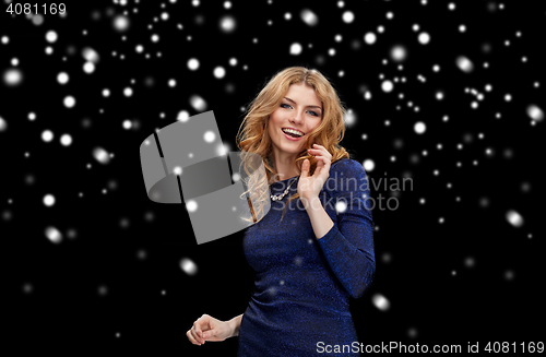 Image of happy young woman dancing over snow