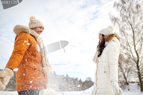 Image of happy couple playing with snow in winter