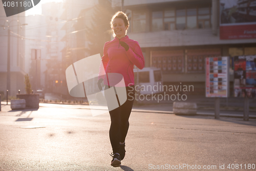 Image of sporty woman jogging on morning