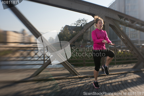 Image of woman  stretching before morning jogging