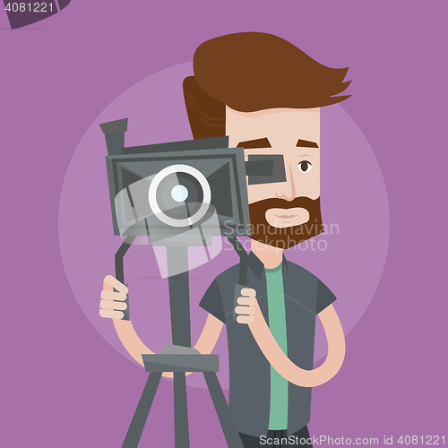 Image of Cameraman with movie camera on tripod.