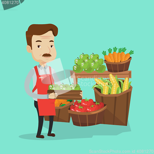 Image of Supermarket worker with box full of apples.