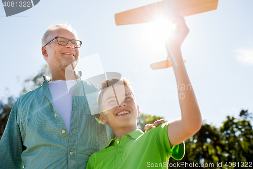 Image of senior man and boy with toy airplane over sky