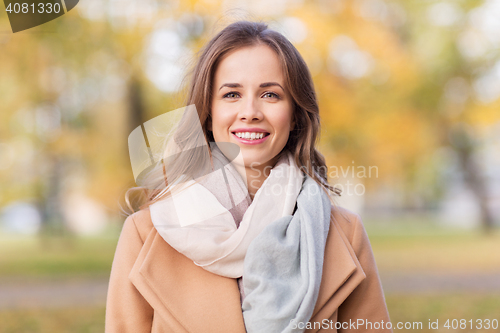 Image of beautiful happy young woman smiling in autumn park