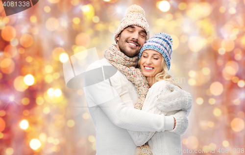 Image of smiling couple in winter clothes hugging