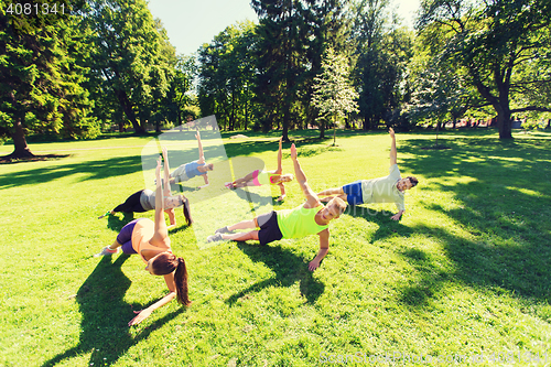 Image of group of happy friends exercising outdoors