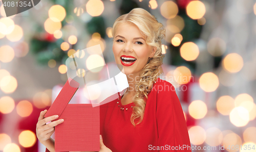 Image of happy woman in red dress with christmas gift box