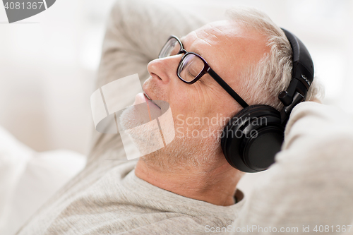 Image of happy man in headphones listening to music at home