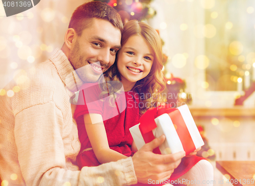 Image of smiling father and daughter holding gift box