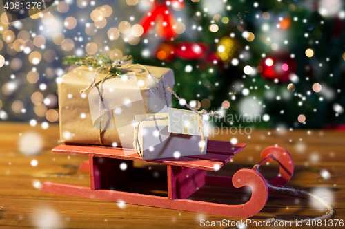 Image of close up of christmas gift boxes on wooden sleigh