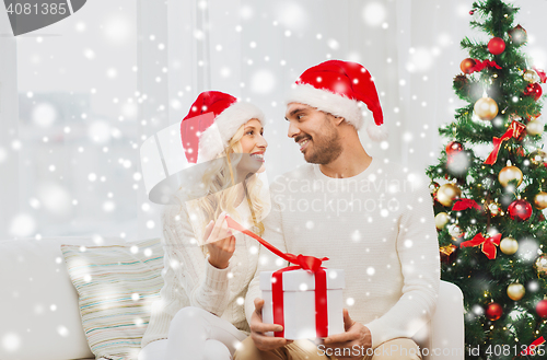 Image of happy couple at home with christmas gift box