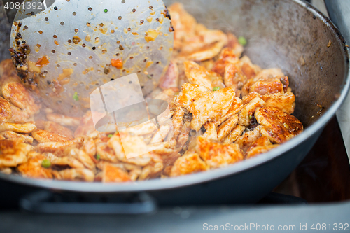 Image of close up of meat in wok pan at street market