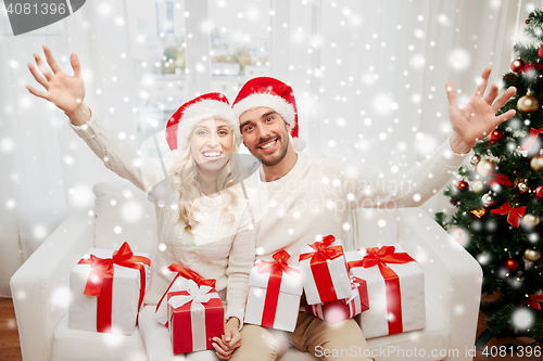 Image of happy couple at home with christmas gift boxes