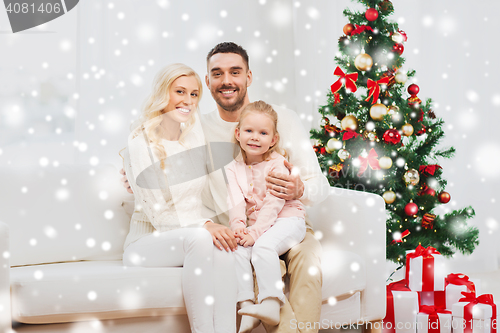 Image of happy family at home with christmas tree