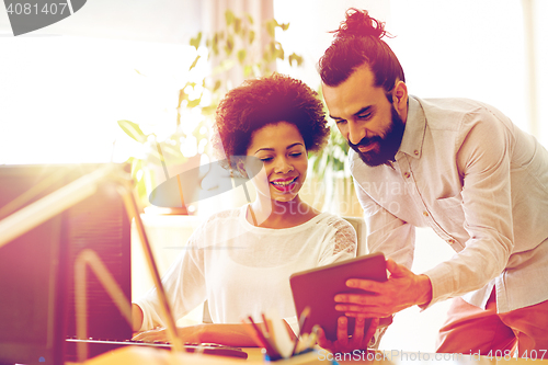 Image of happy creative team with tablet pc in office