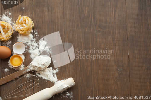 Image of Cuisine composition with cracked eggs,kitchenware, flour.