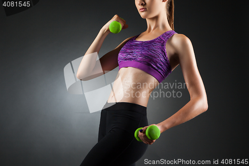 Image of Beautiful anonymous woman doing biceps exercises.