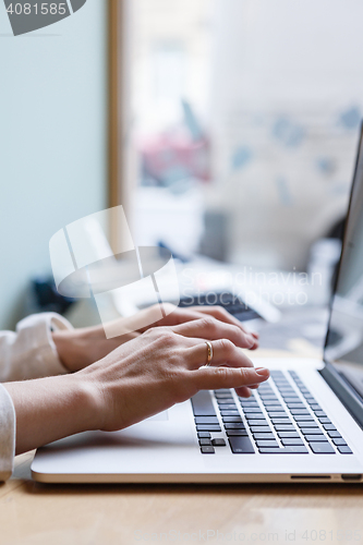 Image of Person writing on laptop