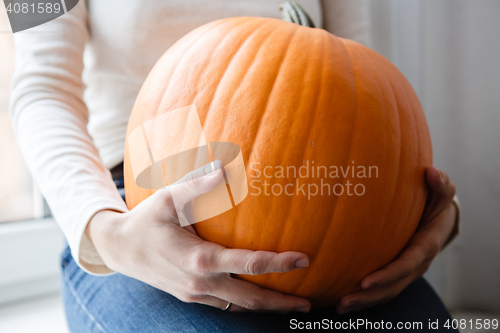 Image of Woman holding big pumpkin