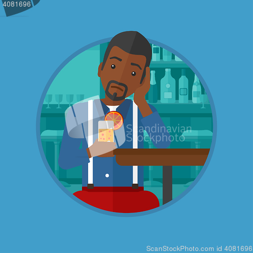 Image of Man drinking orange cocktail at the bar.