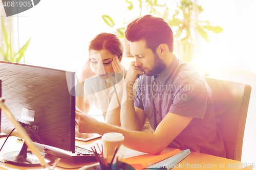 Image of creative team with reading paper in office